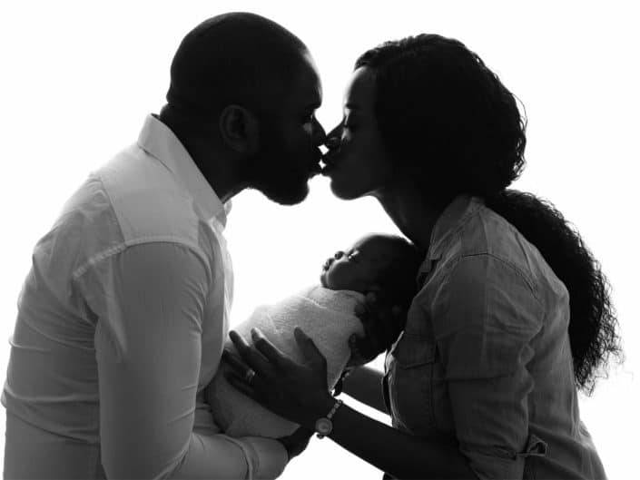 Dark skin parents with newborn baby in arms