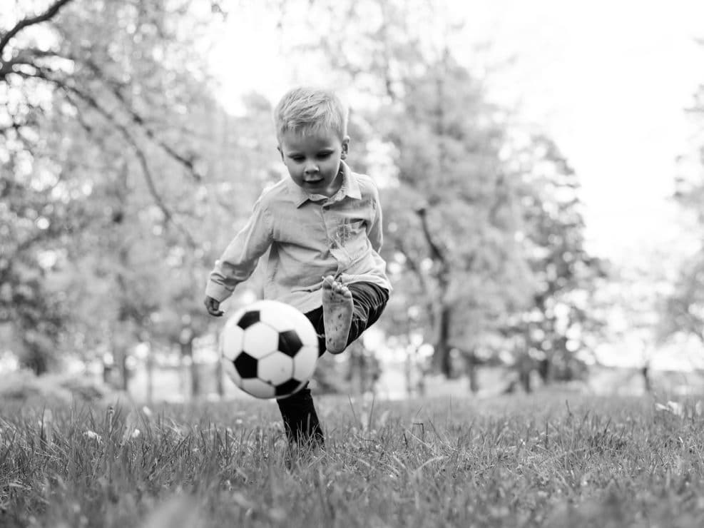Poika potkimassa jalkapalloa