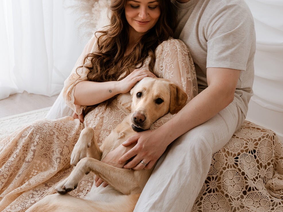 Pariskunta halailee keltaisen labradorinnoutajan kanssa virkatussa viltissä viihtyisässä Jyväskylän kodissa, Madlen Photography, pampasruohon sisustus.